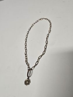 paperclip chain necklace features a circular medallion charm with a centered gemstone detail