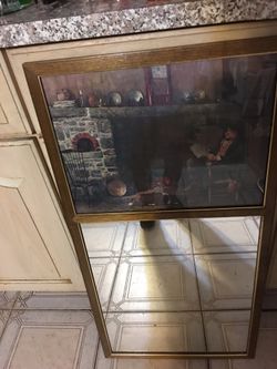 Vintage mirror top has a picture of a man sitting in front of fireplace
