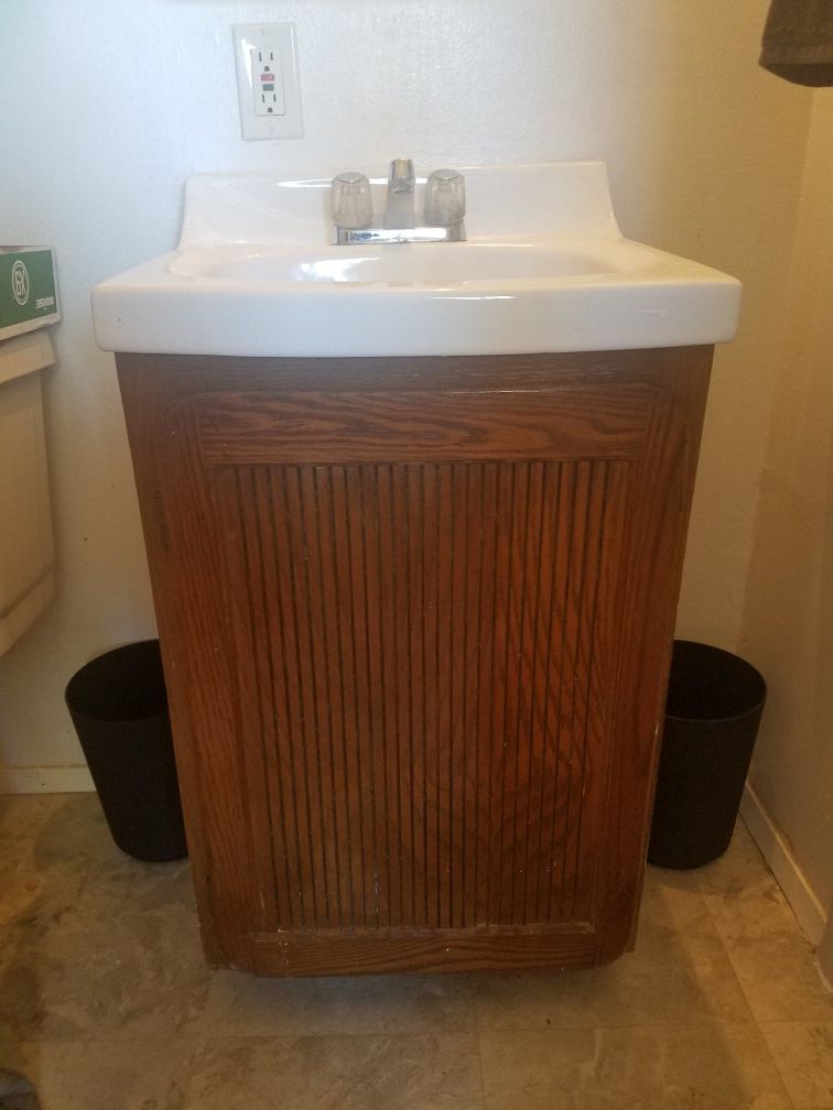 Bath vanity cabinet w/ sink and faucet.