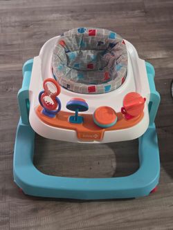 Este es un andador Safety 1st Ready, Set, Walk! DX en color azul y gris con una bandeja de actividades.
