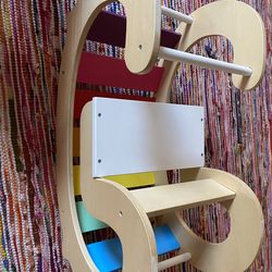 Montessori-inspired wooden rainbow rocker or climbing arch for toddlers.
