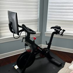 Peloton Bike And Two Pair Of Shoes