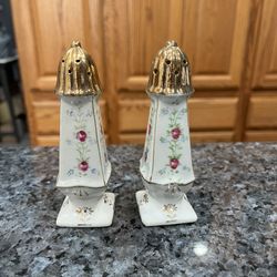 Vintage Hand Painted Porcelain White Floral with gold trim pair of salt and pepper shakers.  Size approximately 4 1/4 inches tall.  Preowned