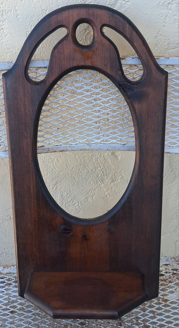 antique-style wooden wall mirror with a small shelf.