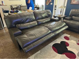 Grey leather reclining sofa and loveseat.