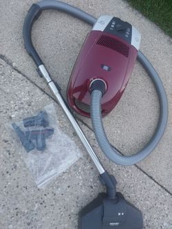 Meile C2 canister vacuum cleaner assembly with attachments. In very good condition fully functional no issues retractable rewind power cord system.  P