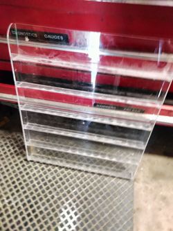 Clear plexiglass nail polish holders mounts towall.