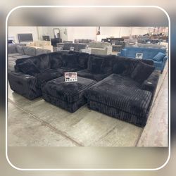 Black corduroy modular sectional sofa with ottoman and cup holder