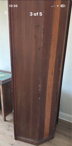 Antique wood corner cabinet. Looks like redwood but I don’t think it is. It is fairly light for its size.