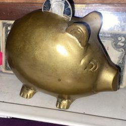 Vintage brass piggy bank with a 2004 proof silver half Kennedy coin