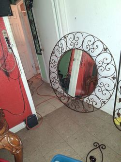 Round beveled mirror with decorative scroll frame casting mirror