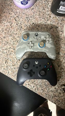 Grey and black Xbox controllers