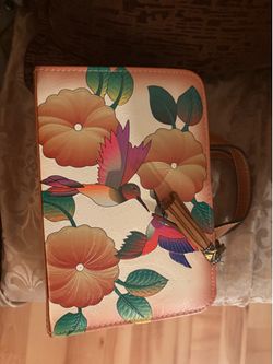 This is a handmade Mexican vegan leather crossbody bag featuring a floral and hummingbird design.