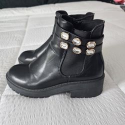 Black leather booties with gold accessories 