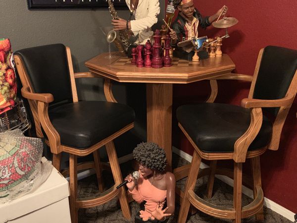 New pub Table with a checker inlay and come with two black bar stool high swivel leather chairs 
