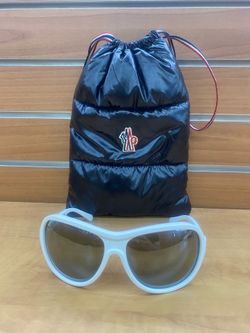 Moncler sunglasses featuring white acetate frames and a logo-embellished protective case