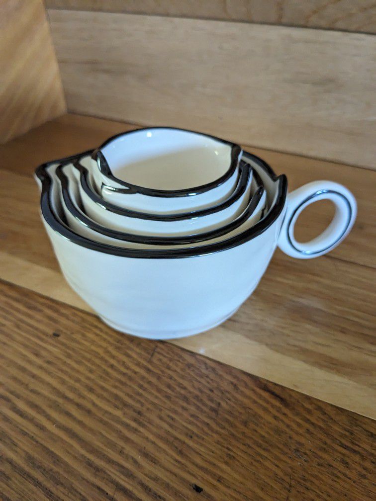 Rustic Stoneware Farmstyle Set Of 4 Nesting Measuring Cups (1, 1/2, 1/3, 1/4 cups). White Base, Black Rim Simplistic Design. 

These measuring cups ar