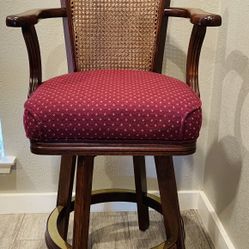 Wood Swivel Bar Stool with Arms – 26” Seat Height Sturdy bar stool with cane back, red cushion, and swivel design.