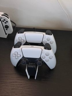 Two PS5 controllers and charging doc