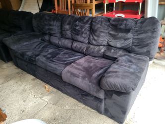 Black couch and love seat. No legs, so they sit low.