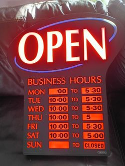Open sign with time table for opening hours and closing