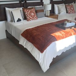 queen bed with brown leather headboard