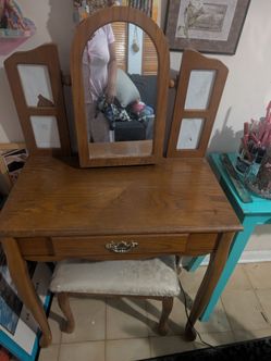 All wood vanity table with seat. The cushion has a plastic cover on it to protect it from spills. I've had this vanity since I was 15 years old and I'
