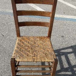 antique wooden ladderback chair featuring a woven rush Seat