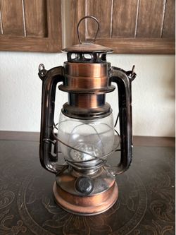 antique-style lantern appears to be a copper-finished LED hurricane lamp