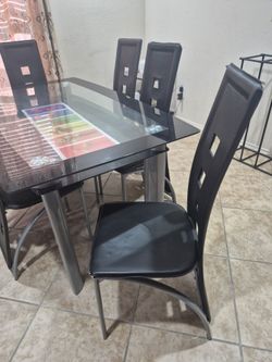 Glass top dinning table with six leather chairs