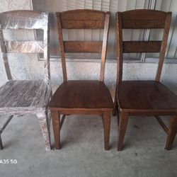 3 SOLID WOOD DINNING CHAIRS .