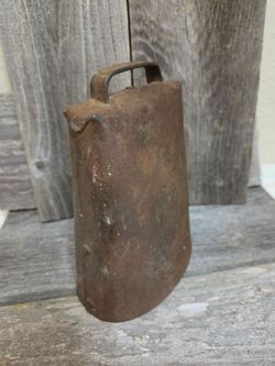 Primative Antique hand-forged metal cowbell featuring folded and riveted...