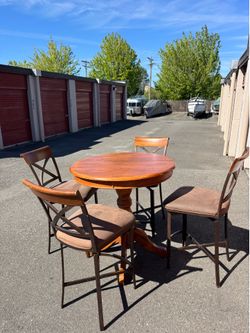Round wooden high table and four chairs