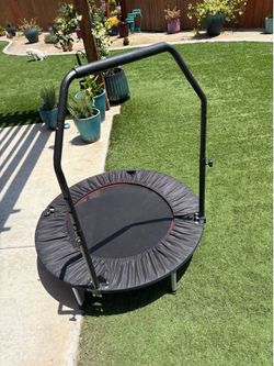 Trampoline exerciser with safety bar
