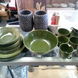 vintage green ceramic dinnerware set featuring embossed botanical or mandala-style patterns along the rims of the plates and bowls