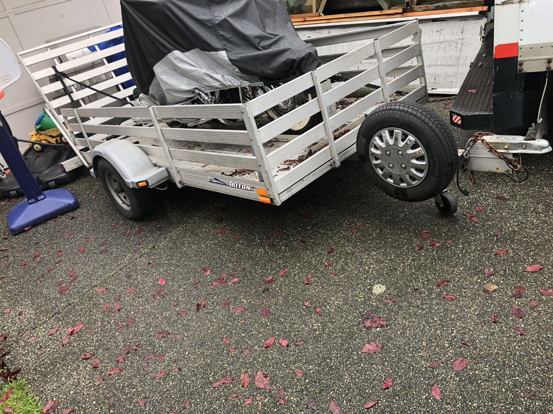Triton aluminum trailer . 9 feet long and about 5feet wide wide bedwith motorcycle front wheels chock and tie downs hooks. Drive up ramp.