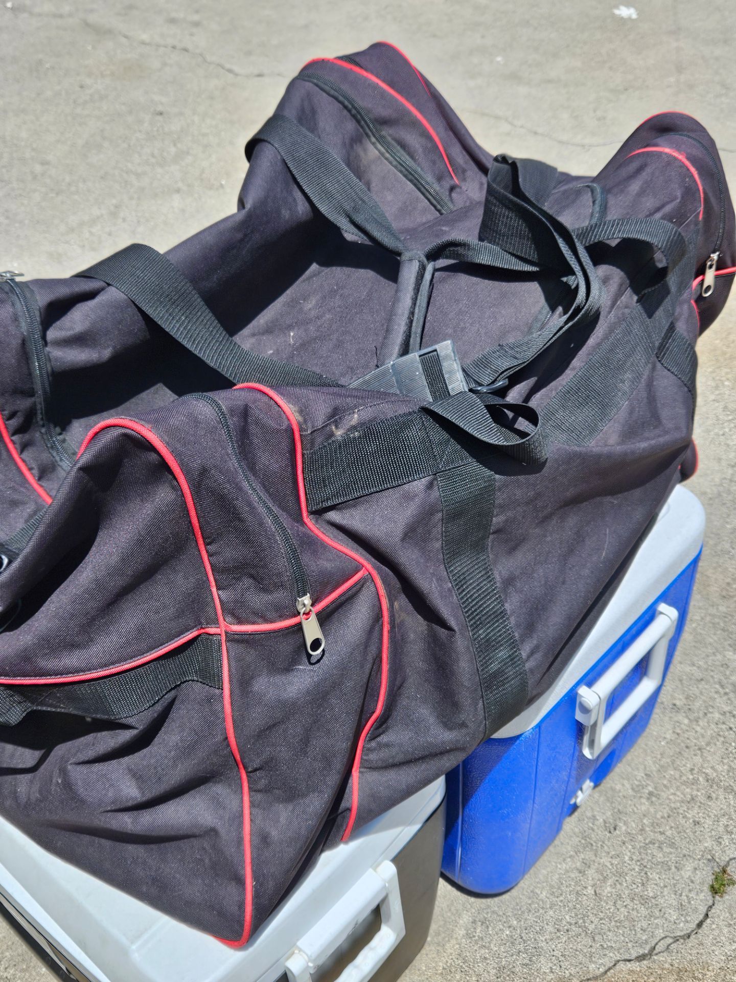 black and red Trackside motorcycle storage bag features heavy-duty straps and zipper closures