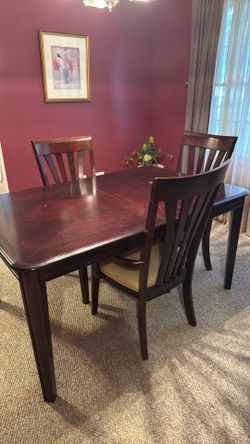 Mahogany colored dining table with 4 chairs and 1 leaf