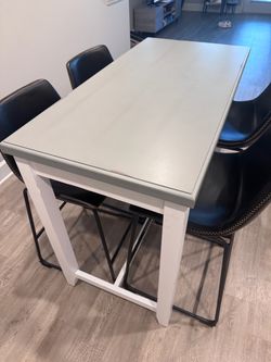 Bar height dining table and 4 cushioned chairs