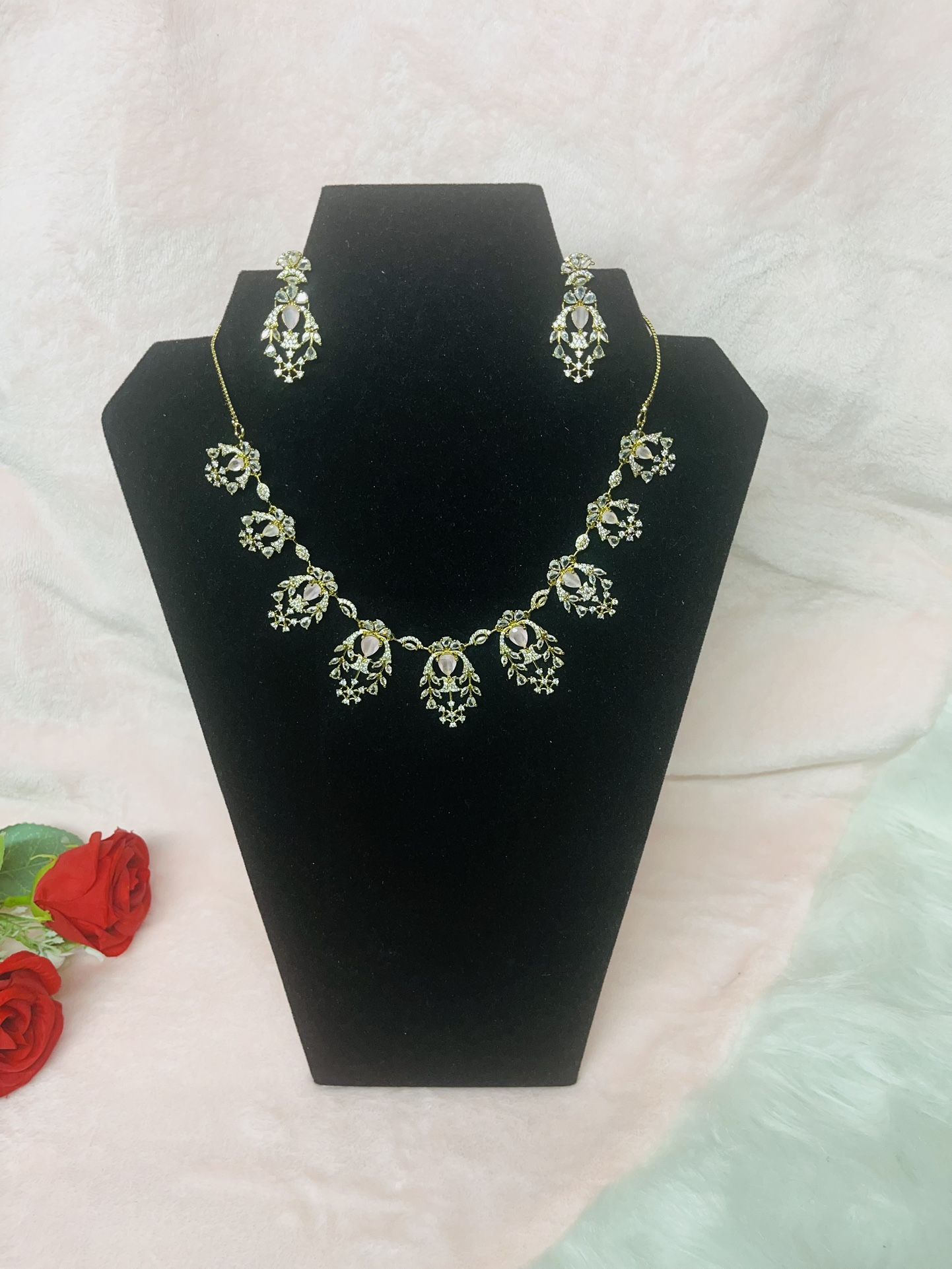 necklace set with matching earrings, featuring a floral motif design with clear and light pink stones.