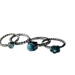 Set 4 twist rope rings w/blue stone, rhinestone & flower, silver/gold 7-8.25  3 are silver tone, 1 is closer to gold.  The rhinestone is a cloudy sky 
