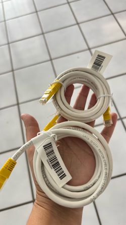 It is a white Ethernet patch cable with yellow protective boots at the ends.