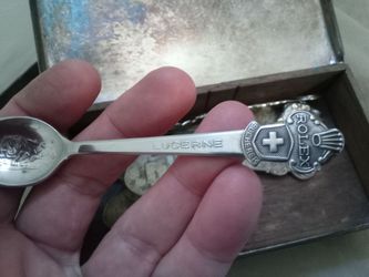 Collectable spoons in a silver tin