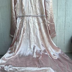 es un vestido largo de color rosa claro con detalles brillantes en el cuello y perlas en la cintura. Debido a que no hay información específica sobre