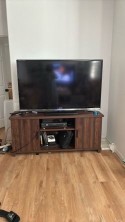 Brown color wood TV stand with TV for 150 have remote it’s working Brown color wood TV stand with TV for 150 have remote it’s working