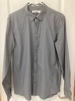 Brand New! Calvin Klein long-sleeve button-down dress shirt with a point collar and subtle micro-pattern fabric. Men size Medium.