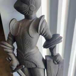 statue of a medieval knight in armor holding a sword and shield. 