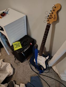 Squire fender guitar with Marshall amplifier and a three pack of Ernie Ball electric guitar strings