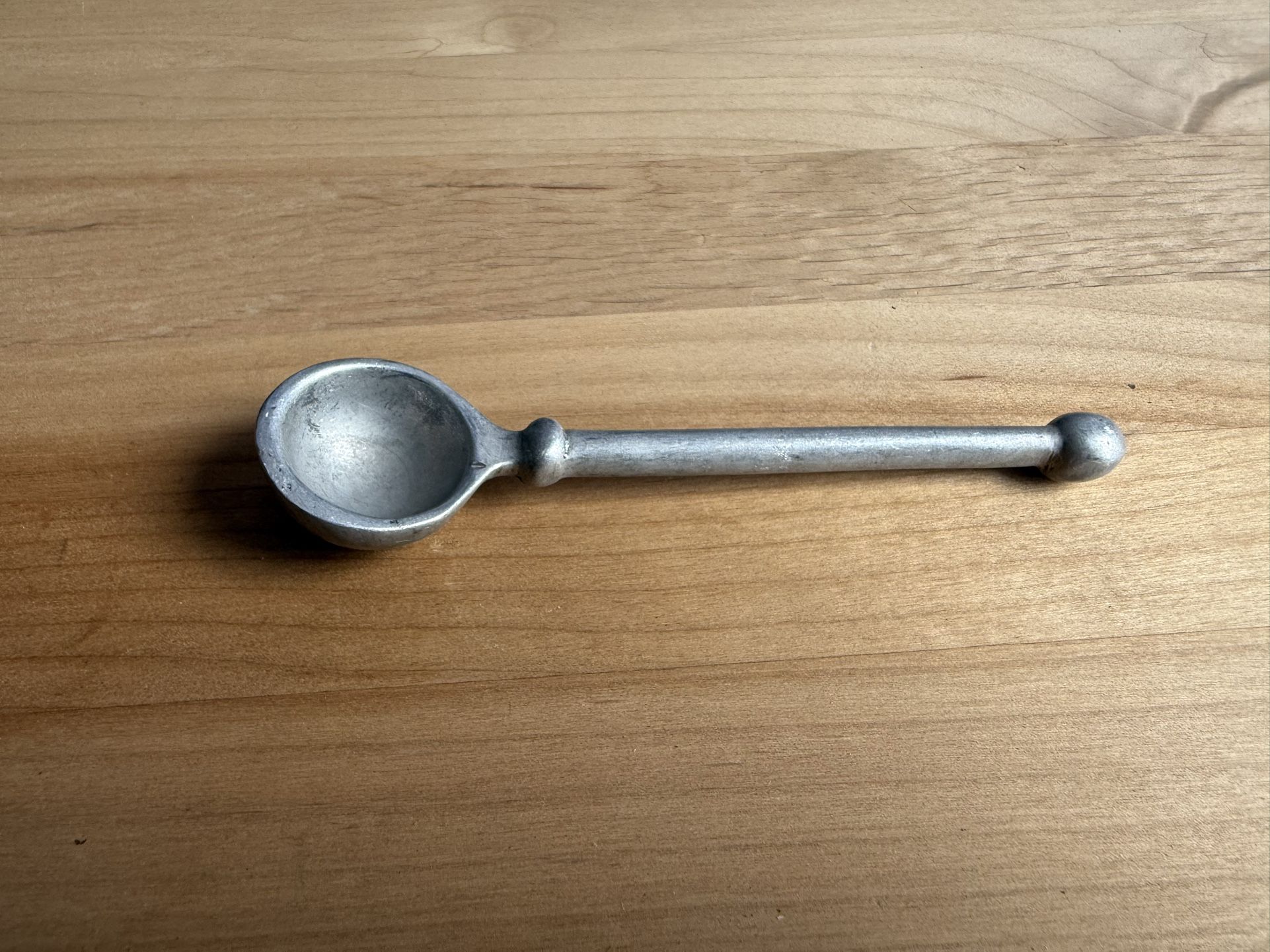 is a vintage pewter tasting spoon used for tasting wine or gourmet food.