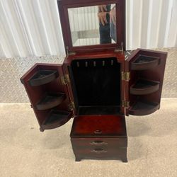Vintage mahogany finish jewelry box armoire manufactured by The Bombay Company. It features a tabletop design with two front-opening doors
